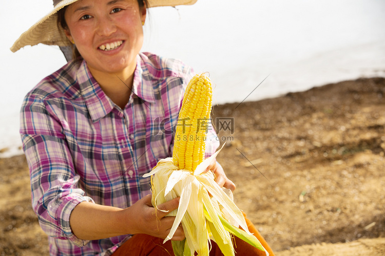 中年女人拿着玉米