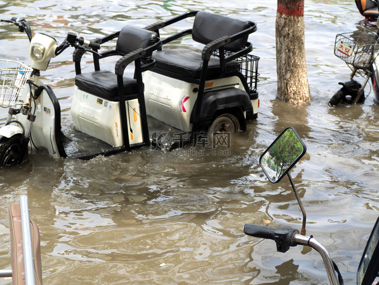 被淹的城市白天电动三轮车雨水中