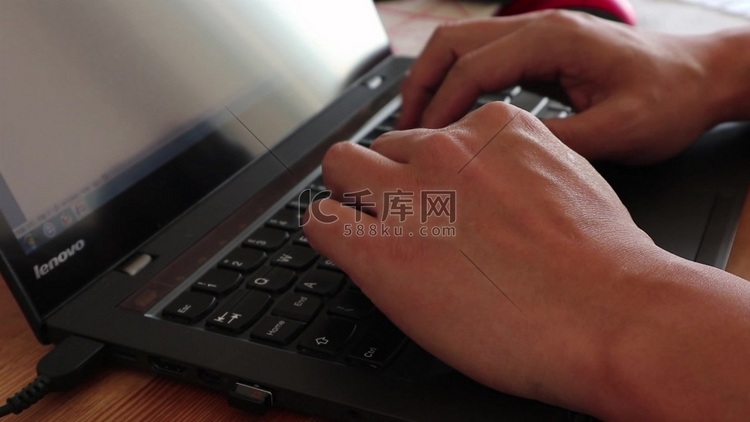 双手在笔记本电脑键盘上打字