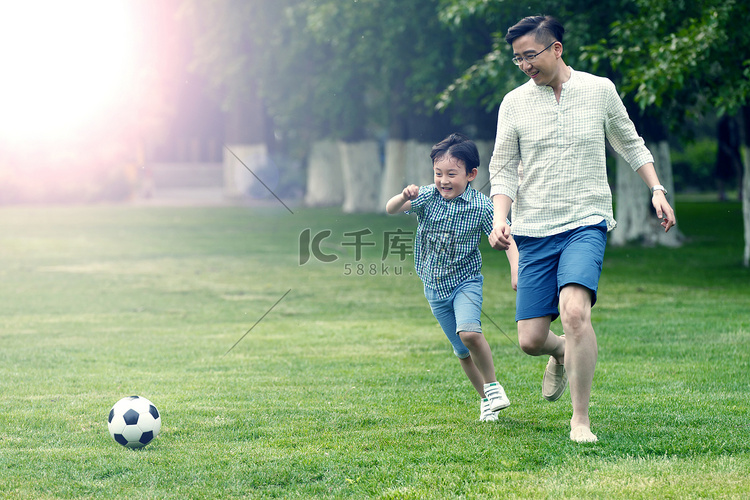 快乐父子在草地上踢足球