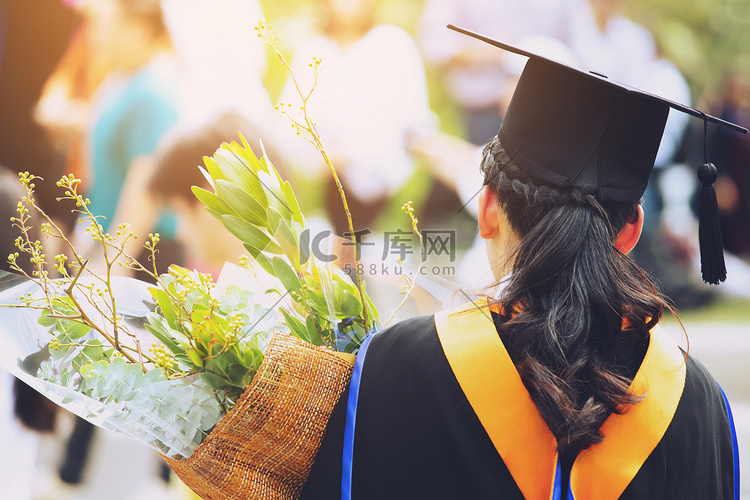 拍背边年轻女学生手捧一束鲜花 