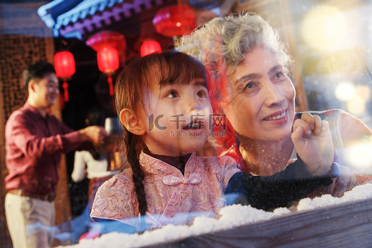 小女孩和祖母看向窗外
