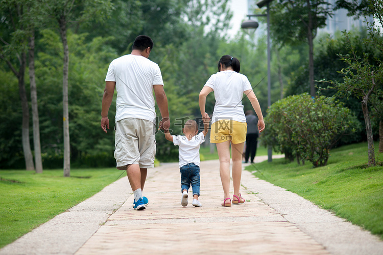 家庭白天父母和孩子公园散步摄影