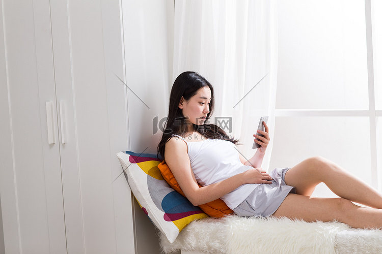 青年女人在卧室用手机