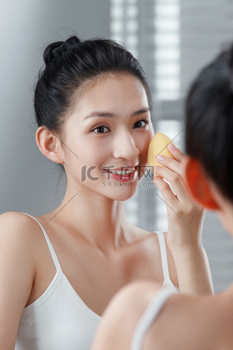 年轻女人对着镜子化妆