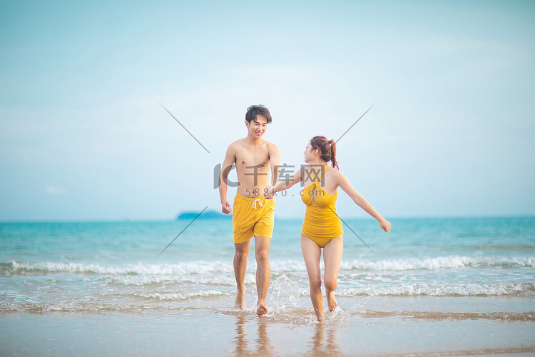 爱情情人节白天一对情侣沙滩手拉