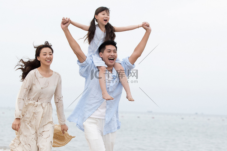 幸福的一家三口在海边玩耍