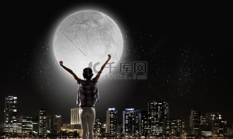 满月。举起双手仰望天空中月亮的