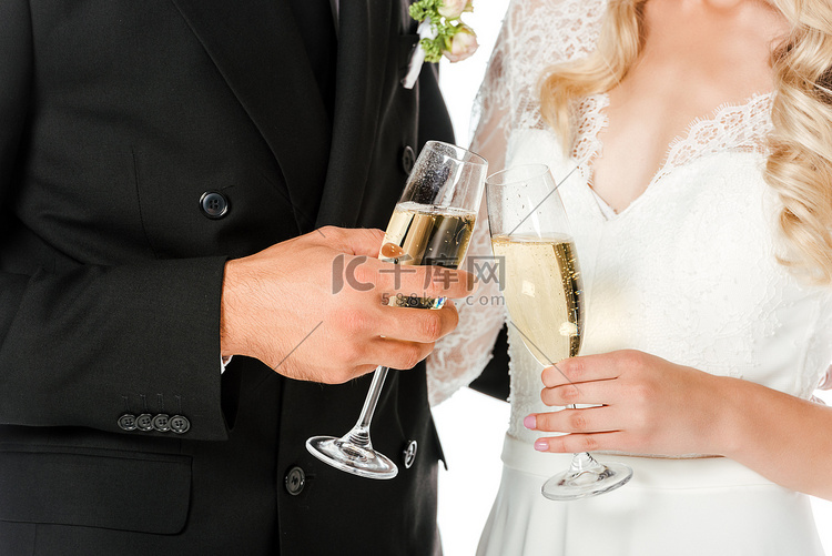 裁剪拍摄的新娘和新郎无比杯香槟