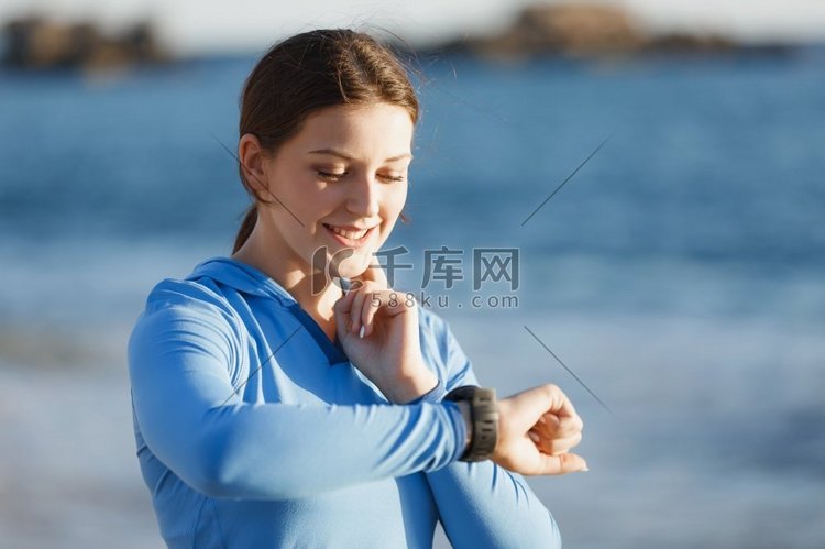 带着心率监测器的女跑步者在海滩