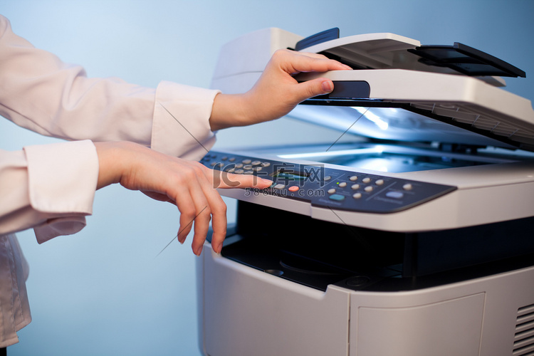 女人的手与工作复印机