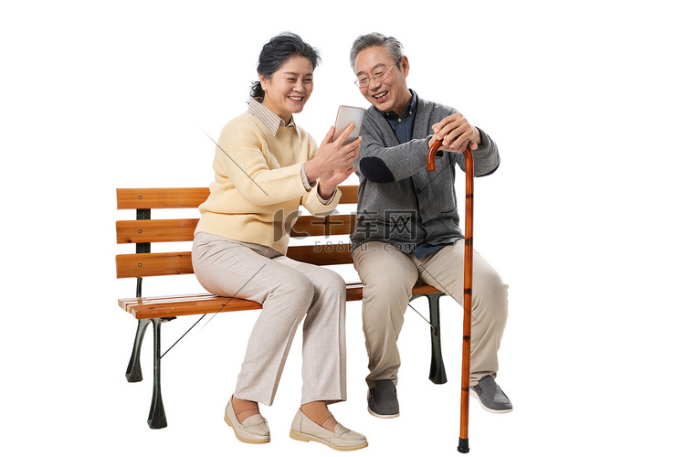 老年夫妇坐在长椅上看手机