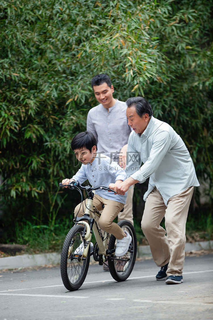 爷爷协助孙子骑自行车