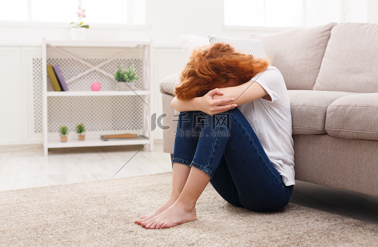 悲伤的女人独自坐在地板上