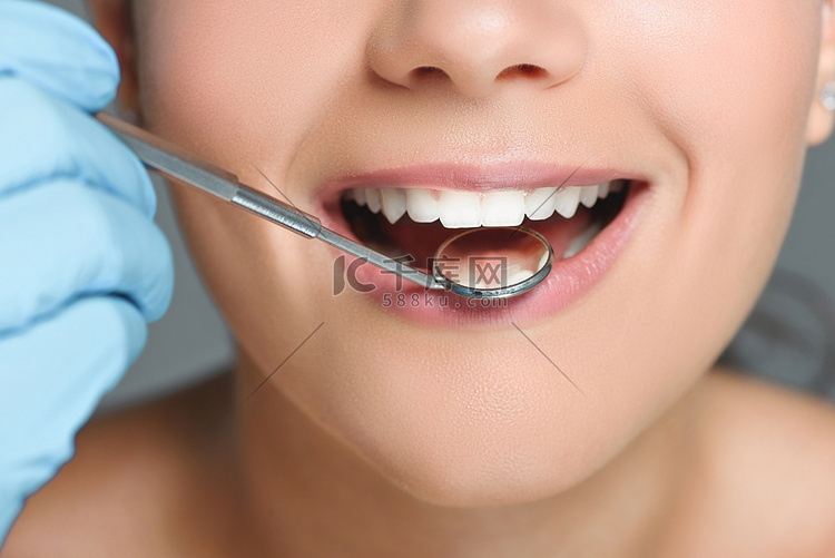 牙科镜检查的牙医的部分看法女人
