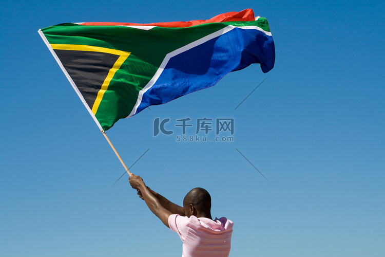 非洲男子挥舞着南非反对蓝蓝的天