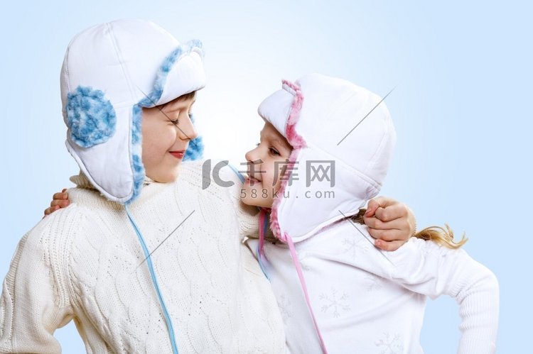 蓝色背景下穿冬装的小孩子的肖像