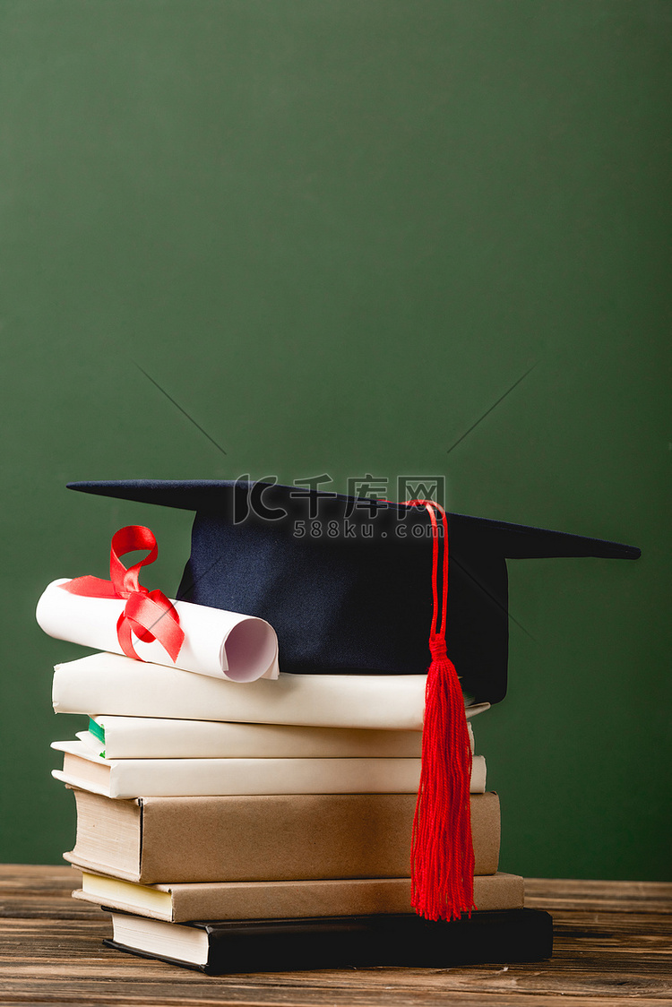 书籍，学术帽和文凭的木制表面隔