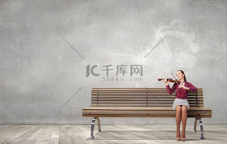 女小提琴手。年轻女子坐在长凳上