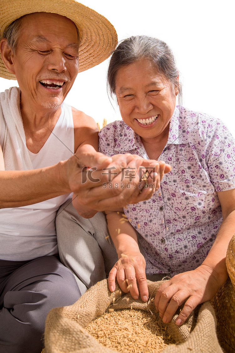 老年夫妇捧着稻谷