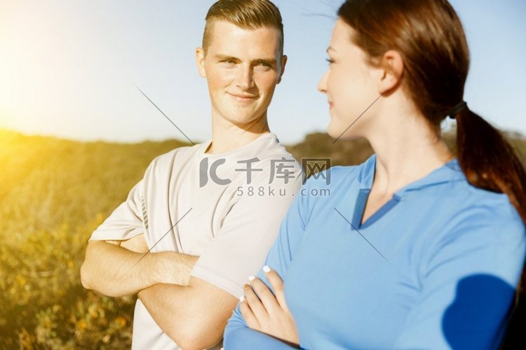 穿着运动服的年轻情侣在海滩上。