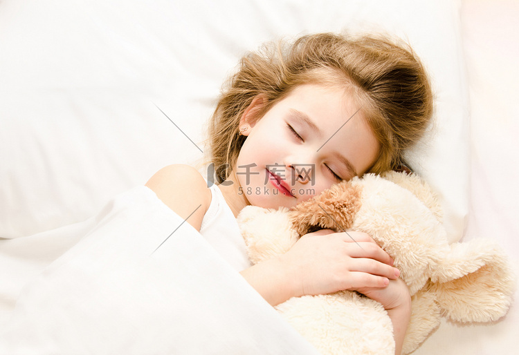 小女孩睡在床上，她的玩具 