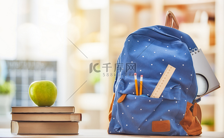 苹果，成堆的书籍与背包