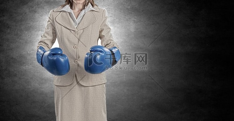 她是个斗士。年轻女商人在蓝色拳