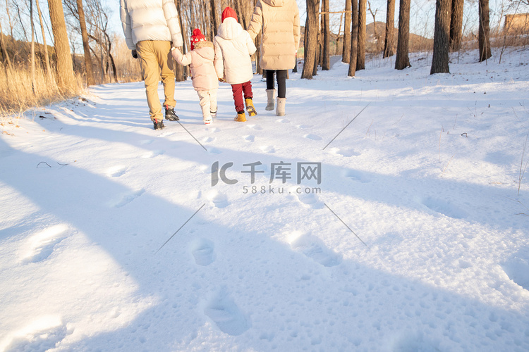 快乐家庭在雪地里散步