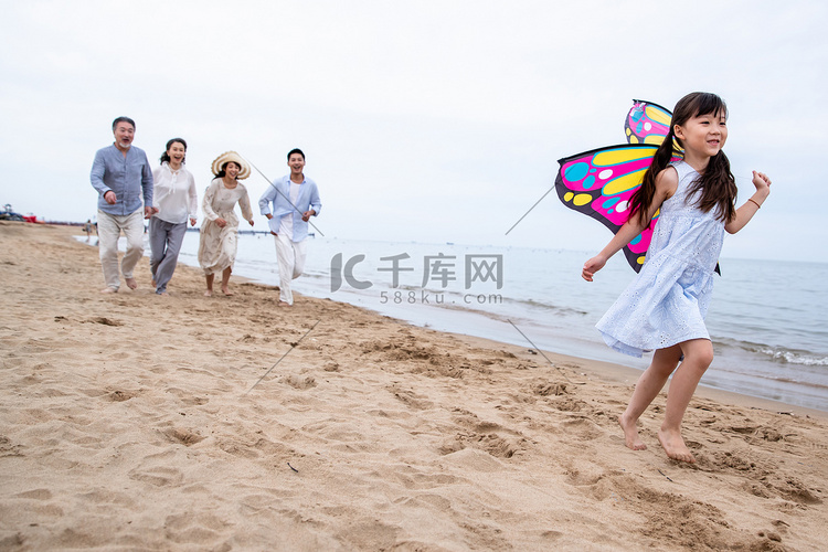 快乐的一家人在海滩上放风筝