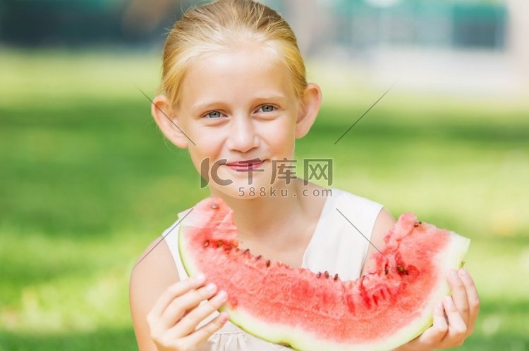 吃西瓜的女孩。可爱的女孩在公园