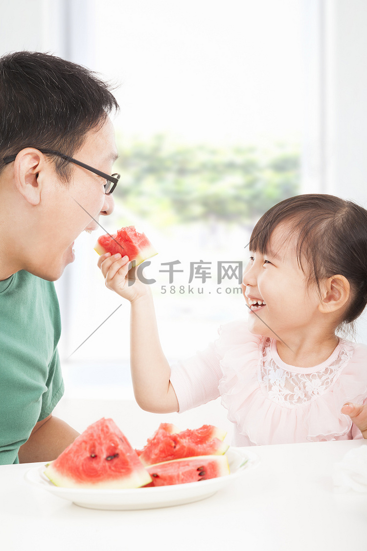 快乐的小女孩与父亲吃水果