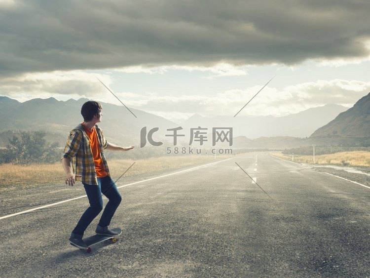 男孩骑滑板。在柏油路上骑滑板的