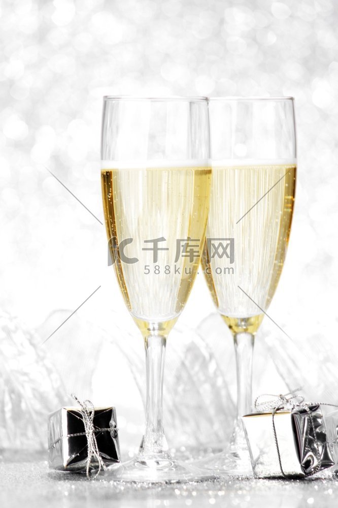 玻璃香槟和圣诞礼物在银色背景