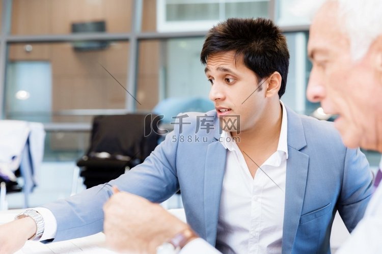 两位在任的商人正在洽谈。讨论是