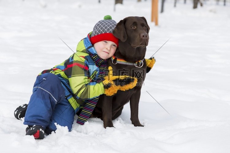 学龄儿童带着狗在冬季公园。我和
