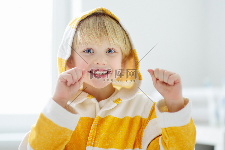 学龄前男孩用牙线清洁牙齿，然后