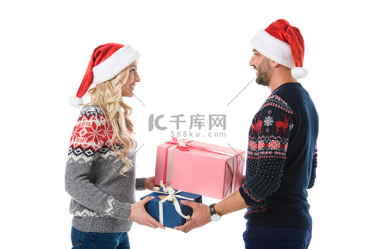 情侣在圣诞毛衣和圣诞老人帽子送