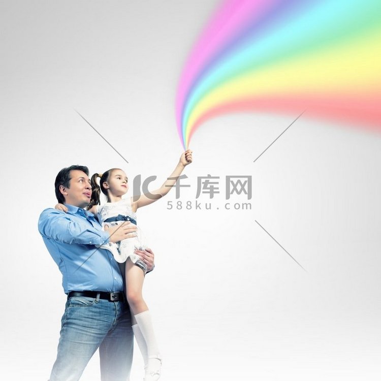 父亲抱着女儿和彩虹。幸福的父亲