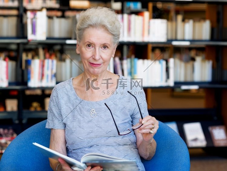 老太太在图书馆看书。花时间读新
