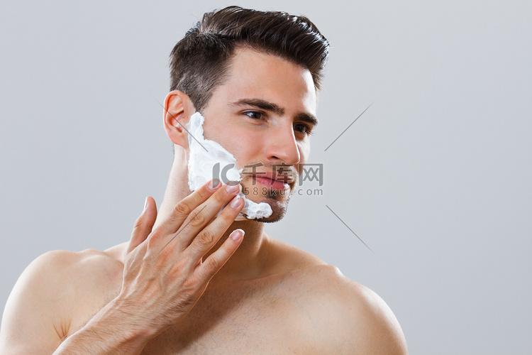 英俊的男人，在他的脸上应用剃须