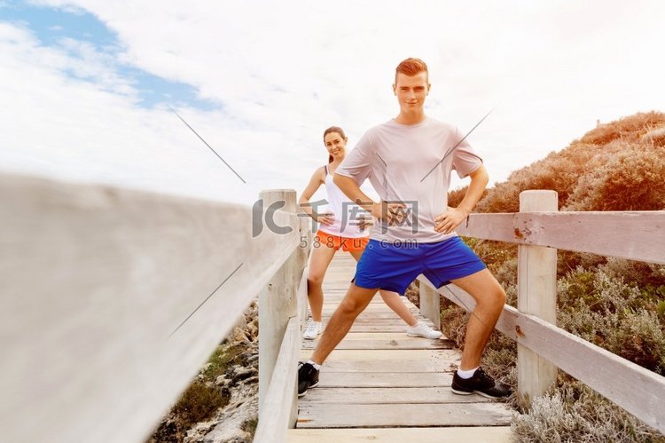 跑步者。一对年轻夫妇在海滩上锻