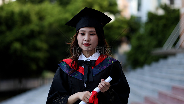 手拿毕业证书黑板穿学士服的大学
