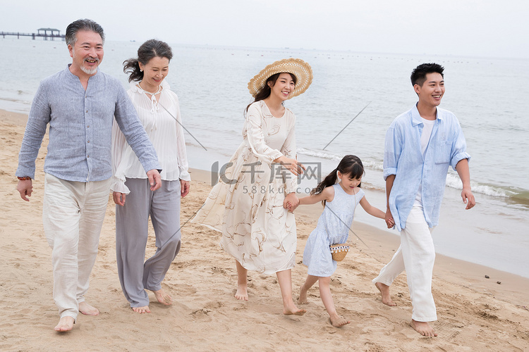 快乐的一家人在海滩上散步