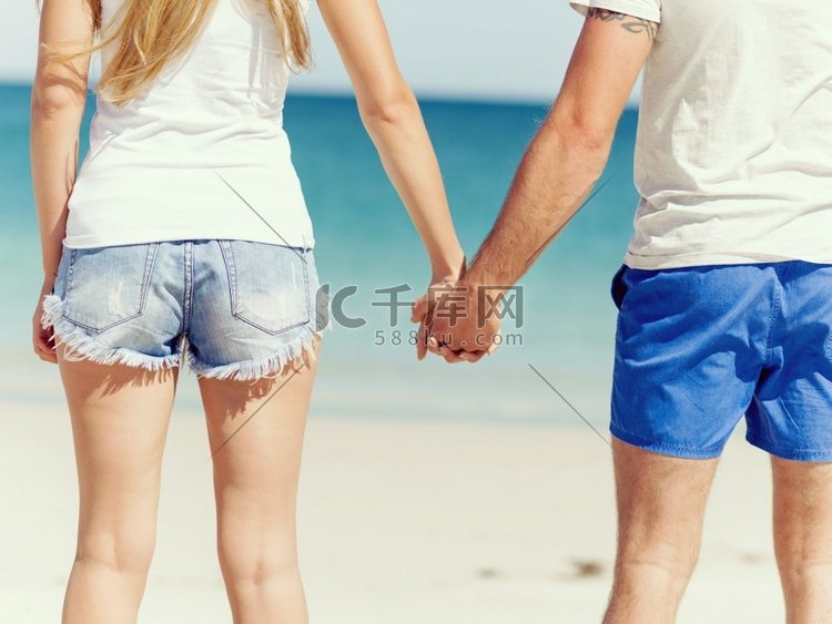 年轻的情侣在海滩上相爱。海滩上