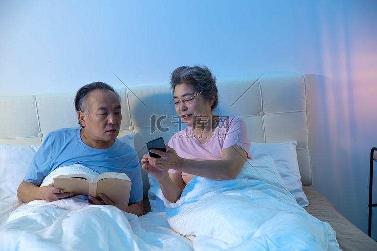老年人坐在床上看手机