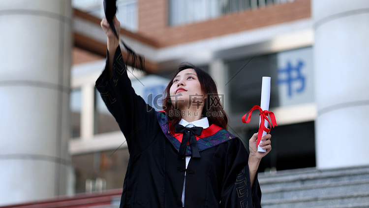 手拿毕业证书黑板穿学士服的大学