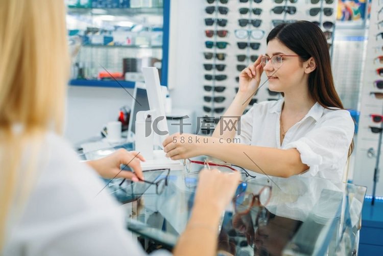 女性眼镜商和消费者在眼镜店选购