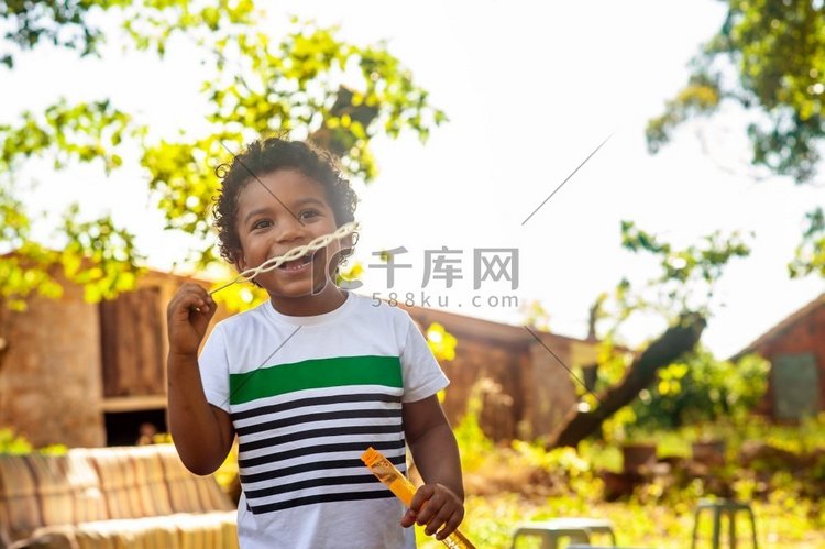 快乐的非洲小男孩在大自然中玩肥