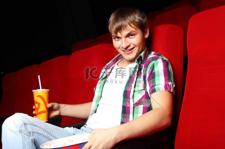 年轻人坐在电影院看电影